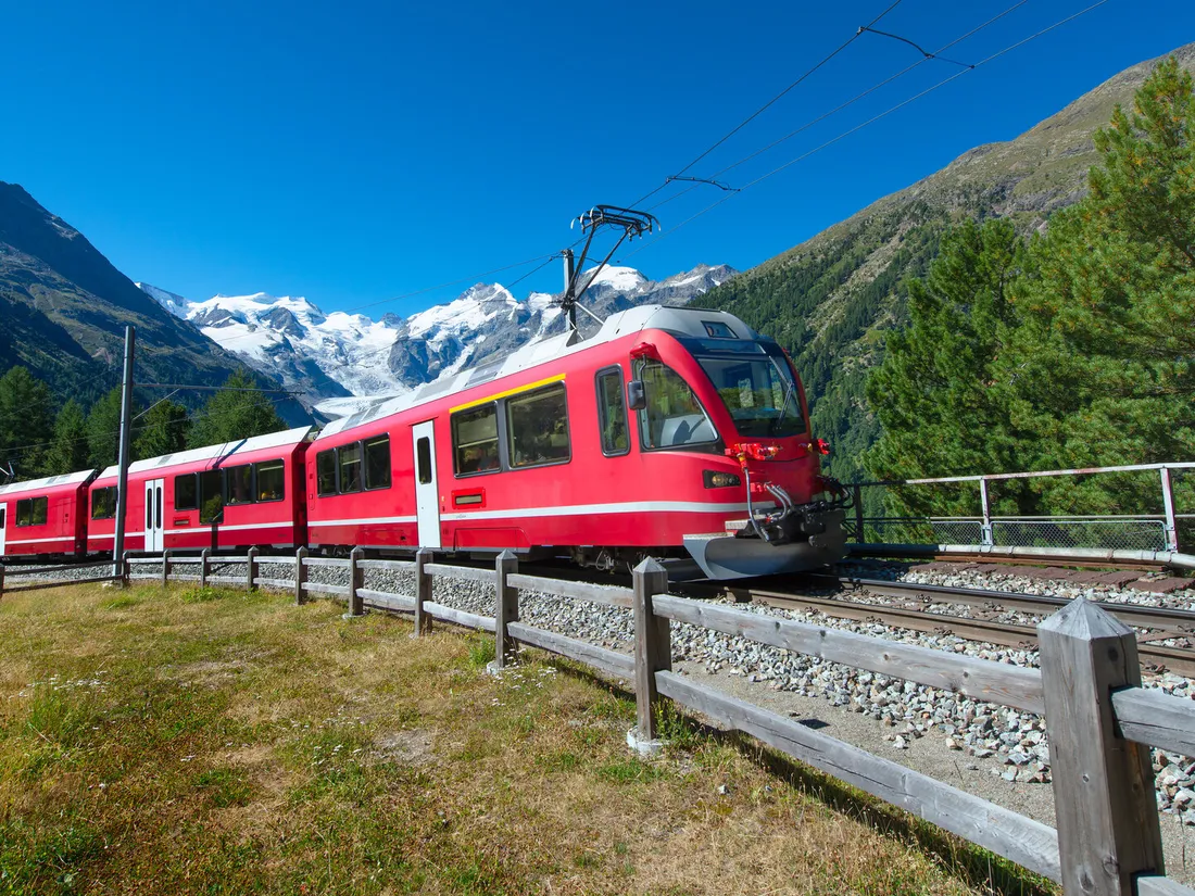 A scenic red train traveling through the mountains