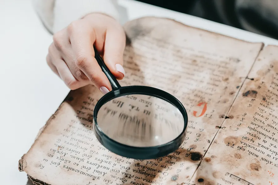 Magnifying glass over the page of an antique book