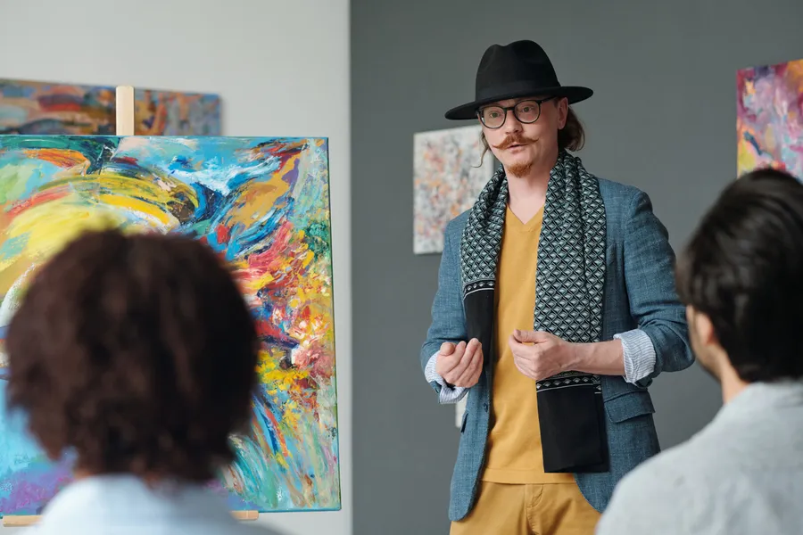 Artist presenting a painting to a small audience