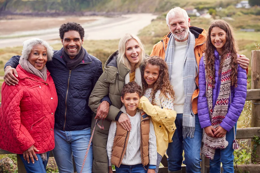Three generations of a family by a wooden fence at the beach