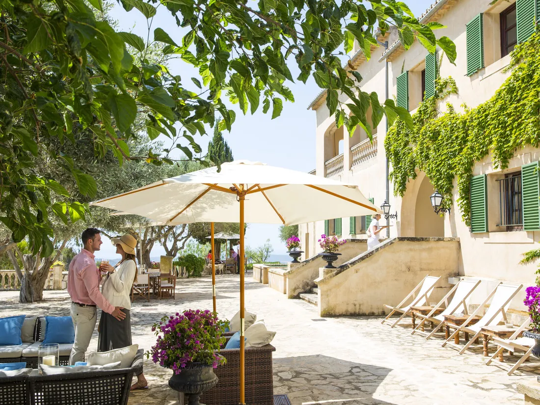 Two guests talking on the patio of a boutique hotel