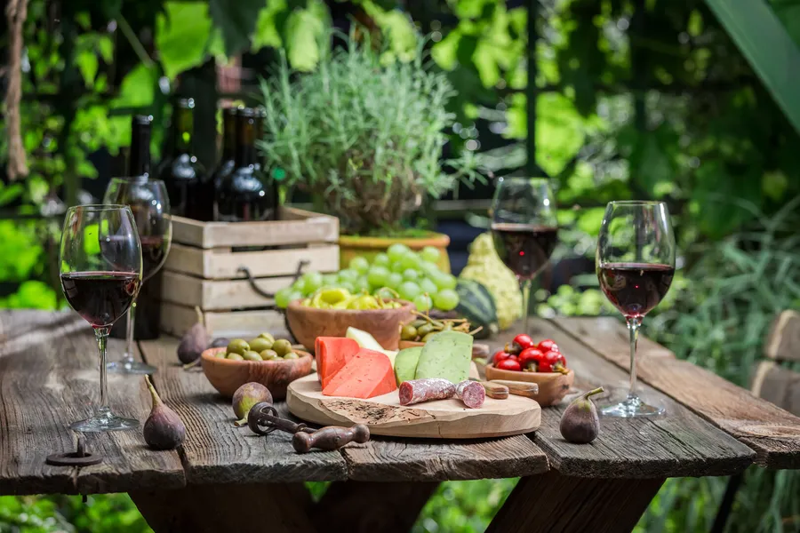 Rustic table set with charcuterie, wine and fruit