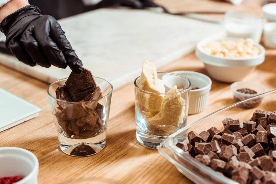 Chocolate and cocoa butter being prepared on a wooden board
