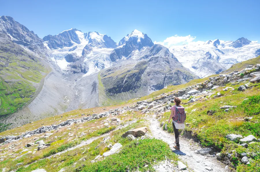 Woman hiking through mountain wilderness on a bright day