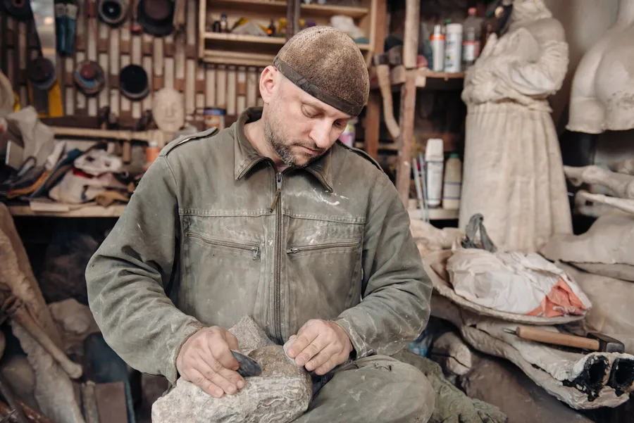 Sculptor at work on a sculpture in his studio