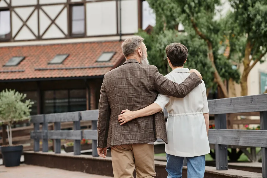 Couple walking arm in arm through a village lane